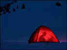 Guy reading in a tent, at dusk, on a snowy mountain. Guy reading in a tent, at dusk, on a snowy mountain.