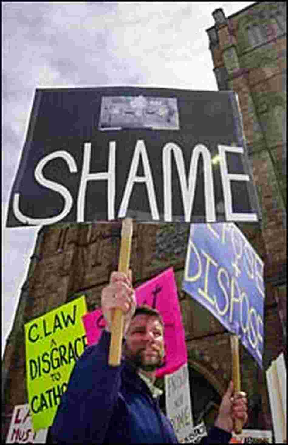 Protesters gather outside the Cathedral of the Holy Cross in Boston, demanding the resignation of C
