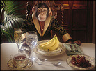 A chimp at dinner with bananas. A chimp at dinner with bananas.