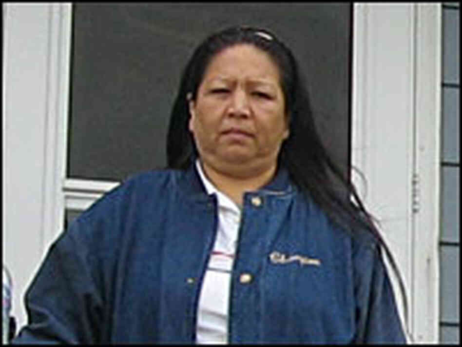 Rhea Archambault standing in front of her home
