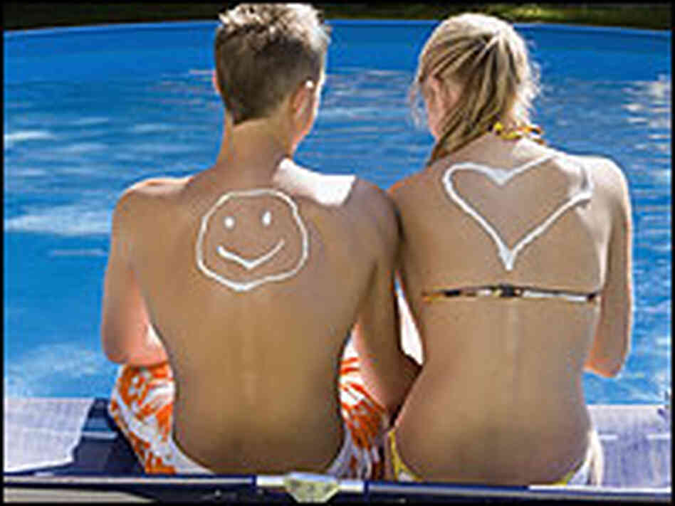 A teenage boy and girl wearing sunscreen at a pool. A teenage boy and girl wearing sunscreen at a pool.