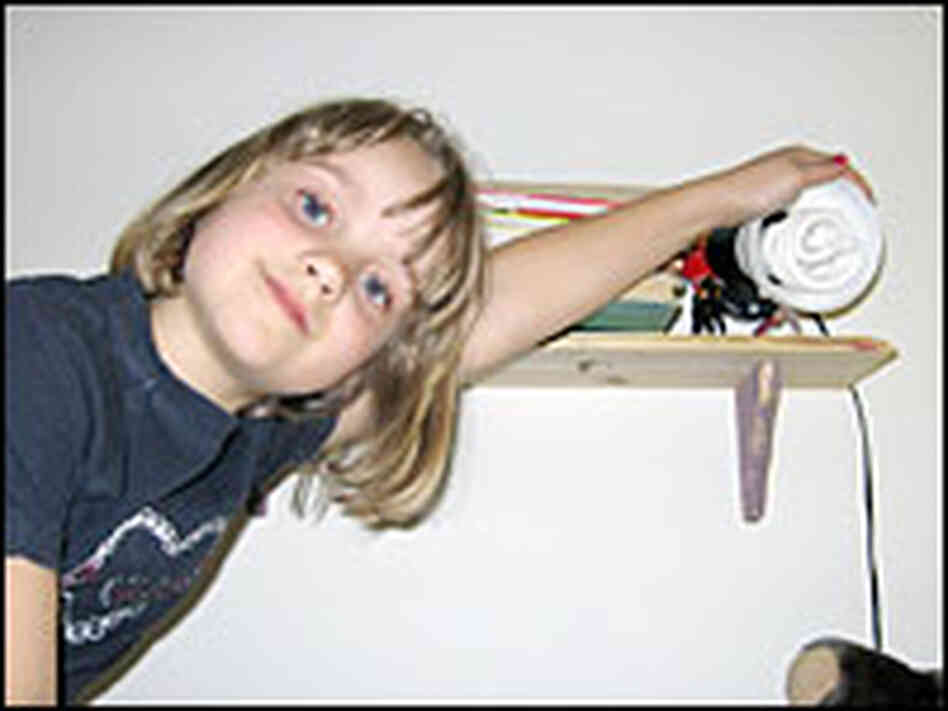 Six-year-old Anja shows off a compact fluorescent light bulb in her room. Six-year-old Anja shows off a compact fluorescent light bulb in her room.