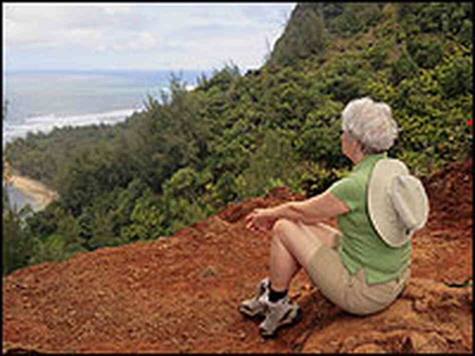 A woman on a hiking trail overlooking an ocean. A woman on a hiking trail overlooking an ocean.