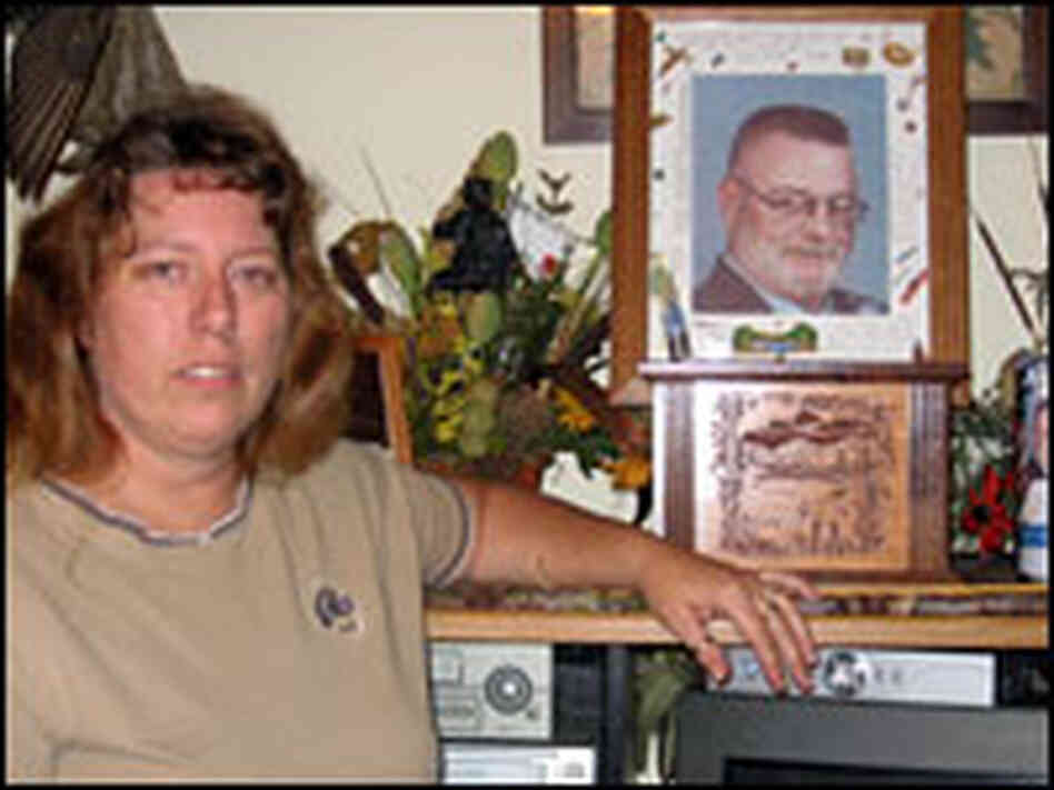 Katrina Shank, standing next to a picture of her late husband, Bob. Katrina Shank, standing next to a picture of her late husband, Bob.