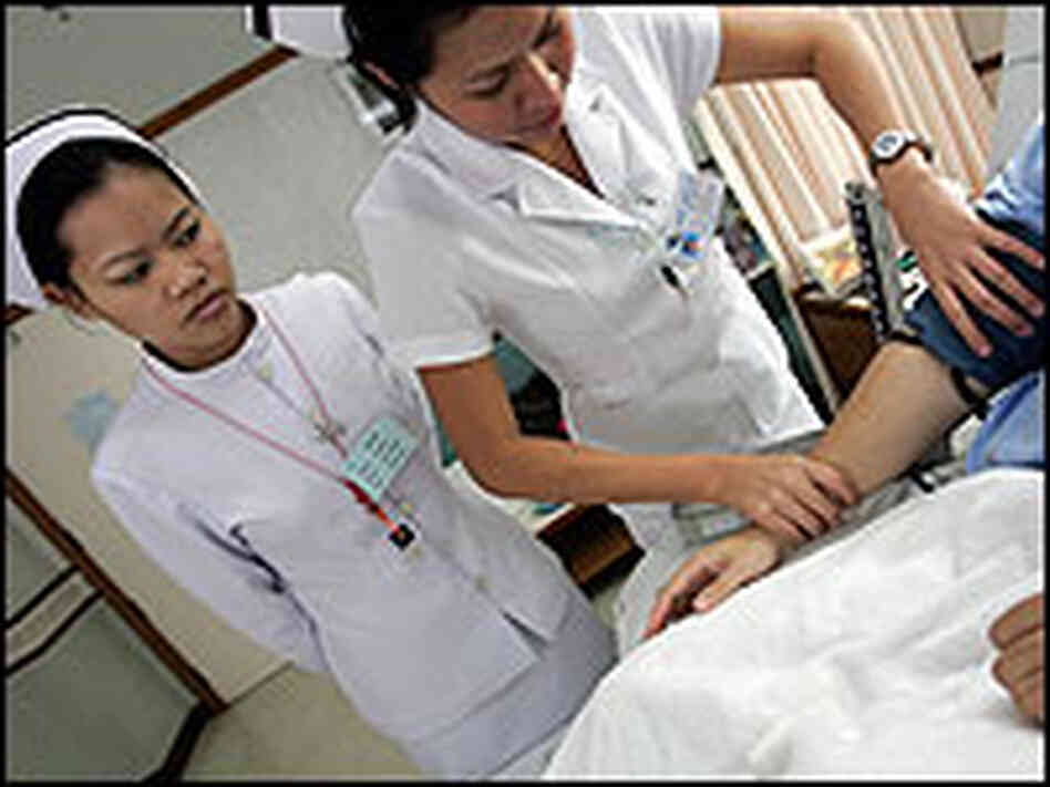 A Thai nurse checks blood pressure of a patient from United States in Bangkok. A Thai nurse checks blood pressure of a patient from United States in Bangkok.