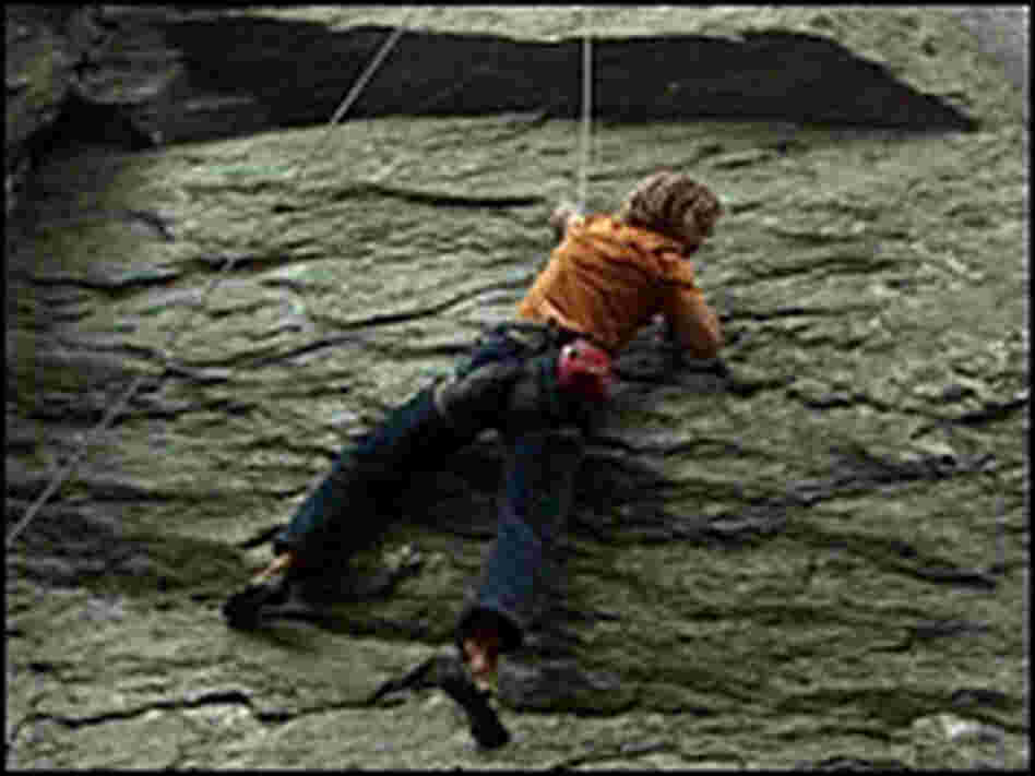 Chris Sharma dangles from a rock face in Carderock.