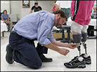 Prothetist David Beachler adjusts Downes' prosthetic legs. Prothetist David Beachler adjusts Downes' prosthetic legs.