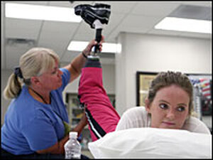 Army Spc. Sue Downes lost both of her legs when the truck she was traveling in was hit by anti-tank mines in Afghanistan. During a recent physical therapy session at Walter Reed Medical Center in Washington, D.C., Downes works with therapist Bunnie Wyckjoff.