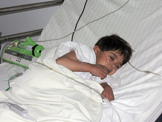 Adila, 6, breathes with the help of an oxygen mask