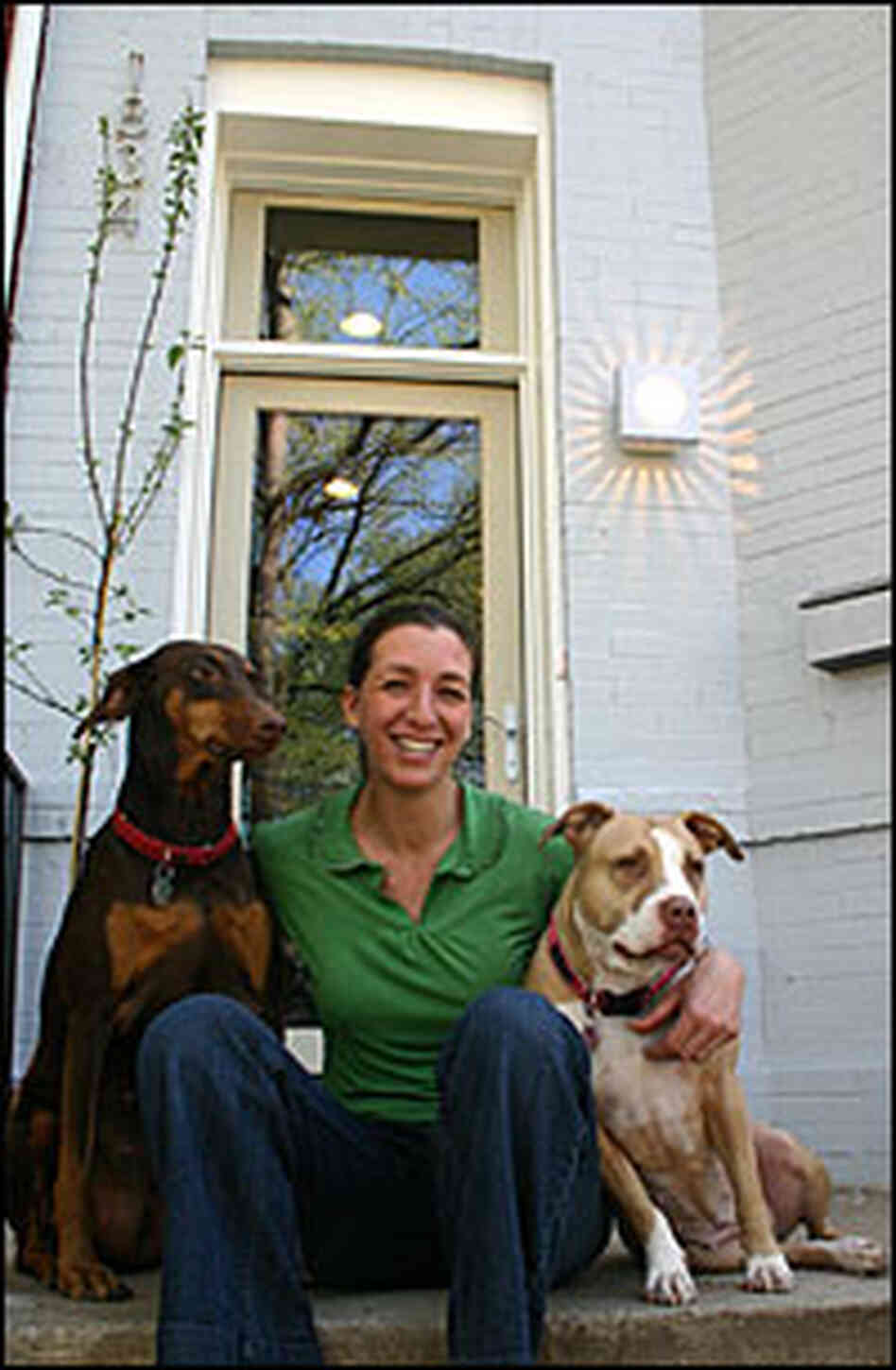 Amy Levin sits on the porch of her newly rehabbed environmentally-friend town house