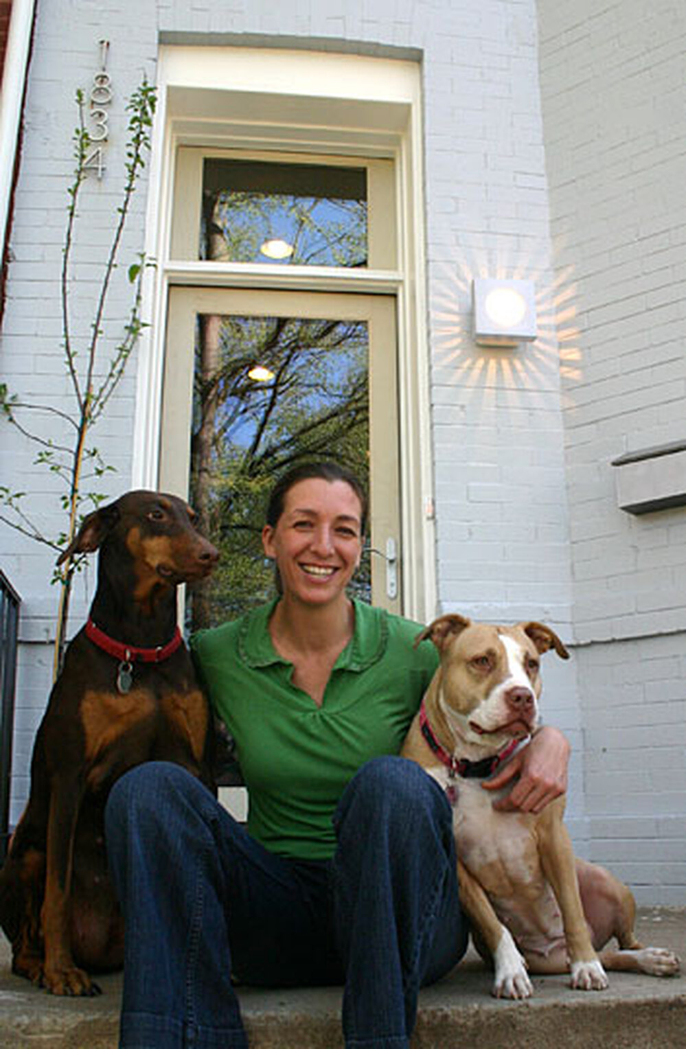 Amy Levin sits on the porch of her newly rehabbed environmentally-friend town house