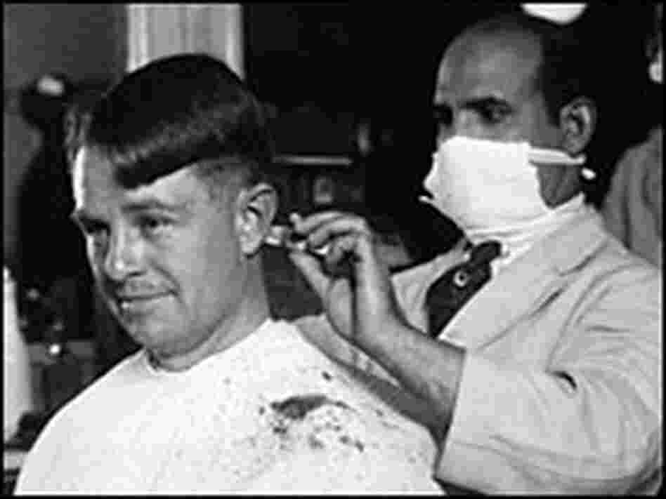 A barber wears a face mask as protection from the flu virus in 1918. A barber wears a face mask as protection from the flu virus in 1918.