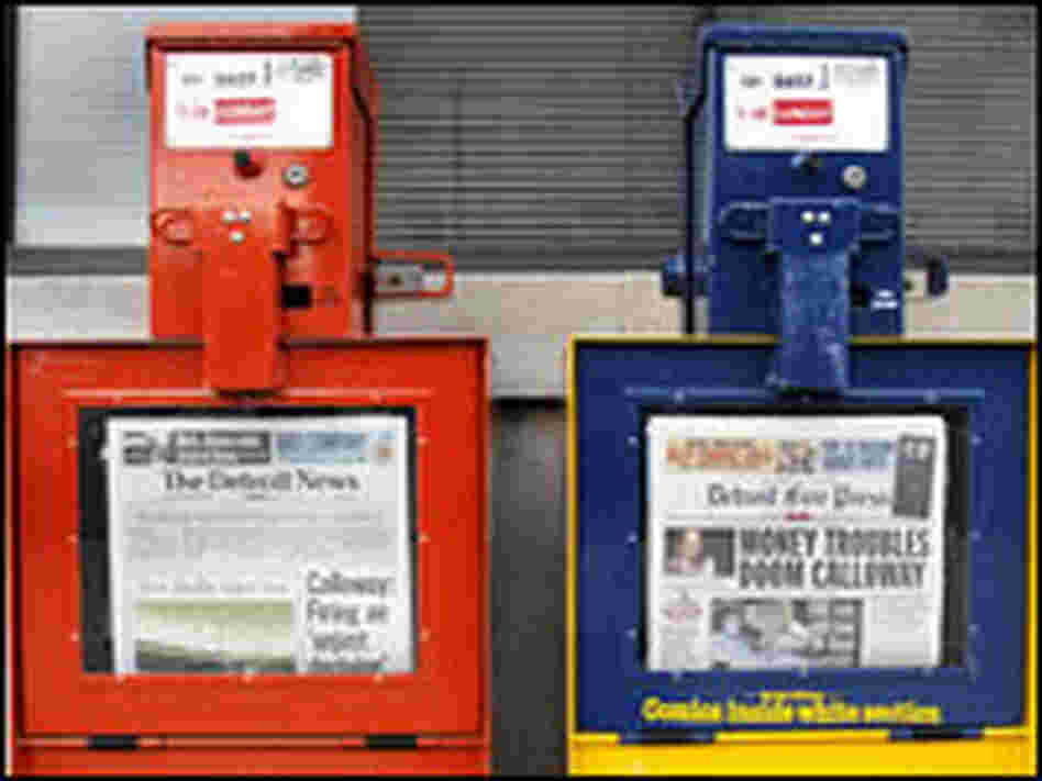 Detroit Free Press and Detroit News newspaper boxes stand in front of newspapers' building.