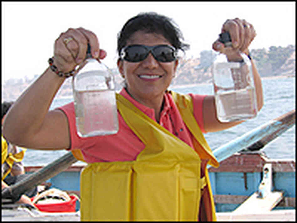 Researcher holding jars of water Researcher holding jars of water