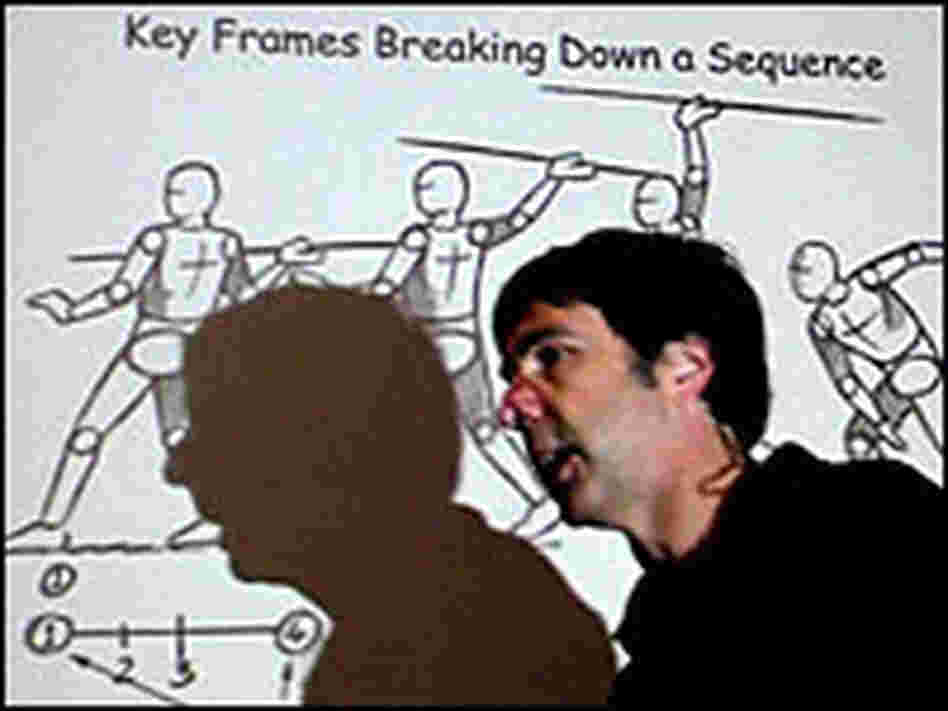 Alejandro Garcia in front of a projected slide Alejandro Garcia in front of a projected slide