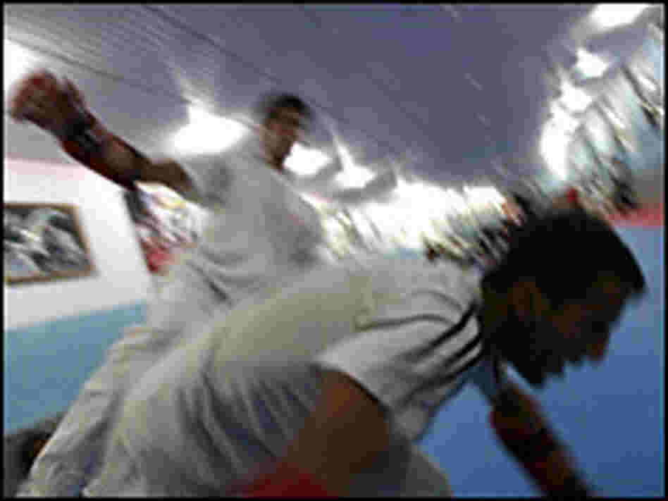 Bahawe slams a teammate to the mat with a roundhouse kick to the side during a sparring match.