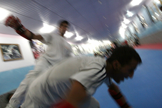 Bahawe slams a teammate to the mat with a roundhouse kick to the side during a sparring match.