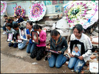 Parents hold pictures of their children who died in the school.