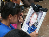 One mother cries as she looks at a picture of her son she lost in the earthquake.
