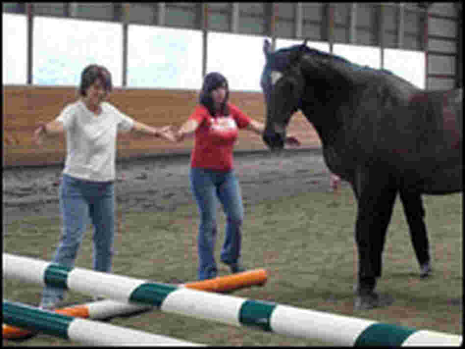 Bonnie Flynn (left) and Kristina Berger try to corral a horse.