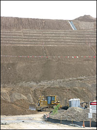 In the past six months, workers have built a half-mile berm across the gulch. The pile of dirt is about 180 feet high and almost 800 feet wide at its base. A Border Patrol road will run atop it eventually.
