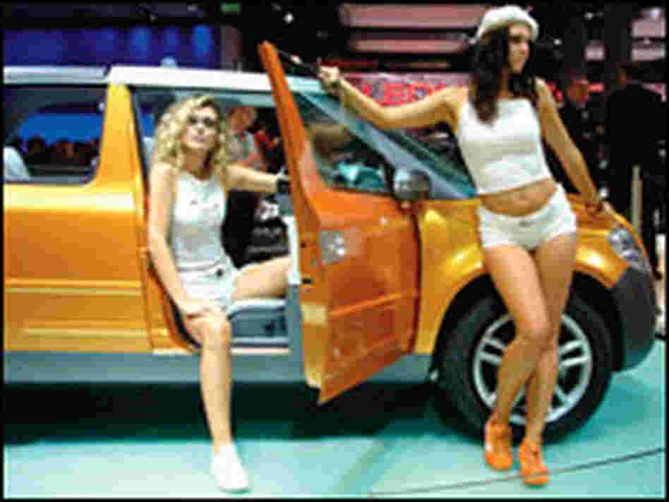 Models show off a golden concept car by Czech automaker Skoda at the 2005 Frankfurt Auto Show.