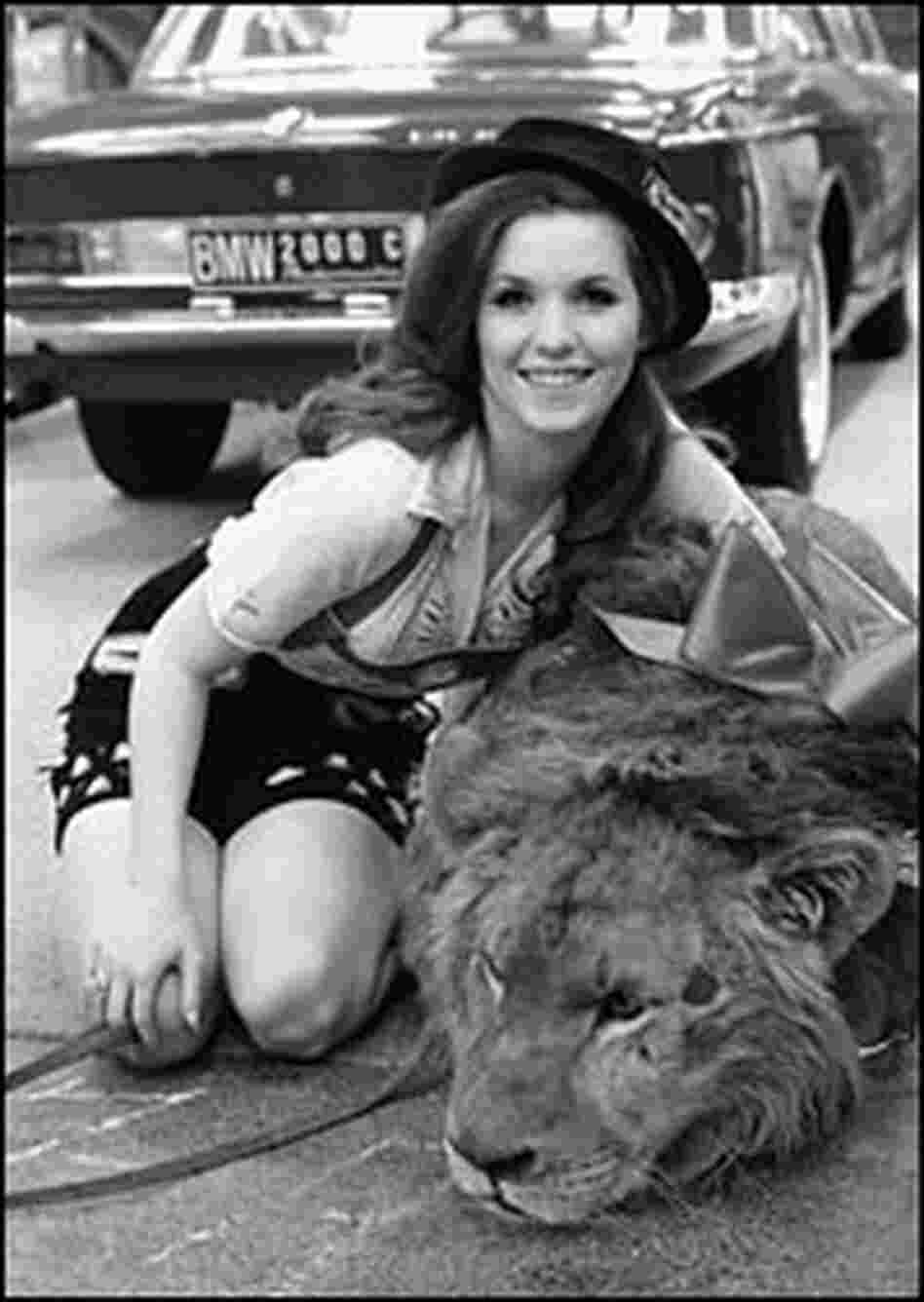 Nell Theobald poses with a lion in the New York Coliseum while promoting the International Auto Show