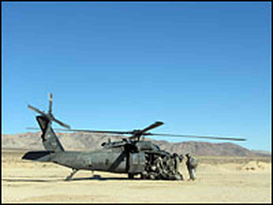 Troops board a helicopter at the National Training Center
