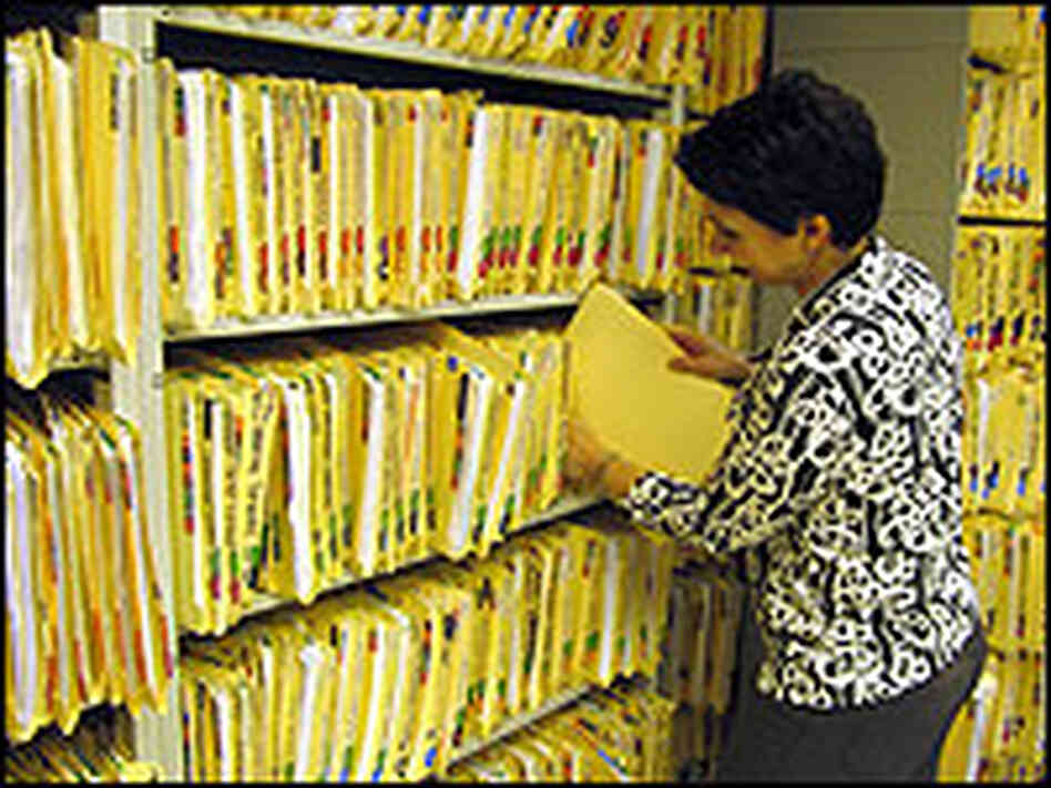 A woman files medical records. A woman files medical records.