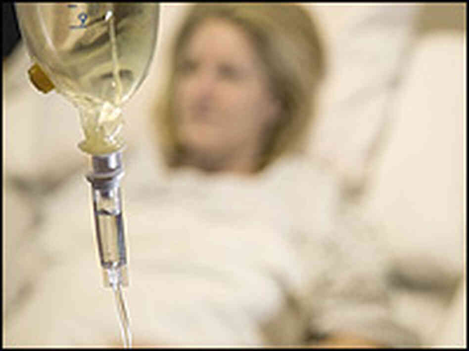 A woman receives an infusion from an IV drip. A woman receives an infusion from an IV drip.