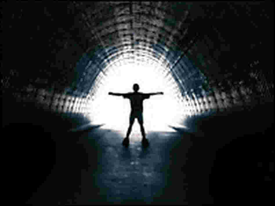 Person in a tunnel walking toward light.