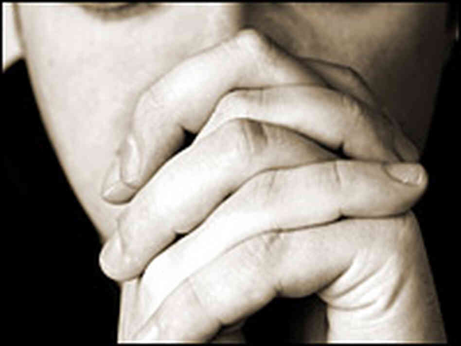A man clasps his hands in prayer A man clasps his hands in prayer