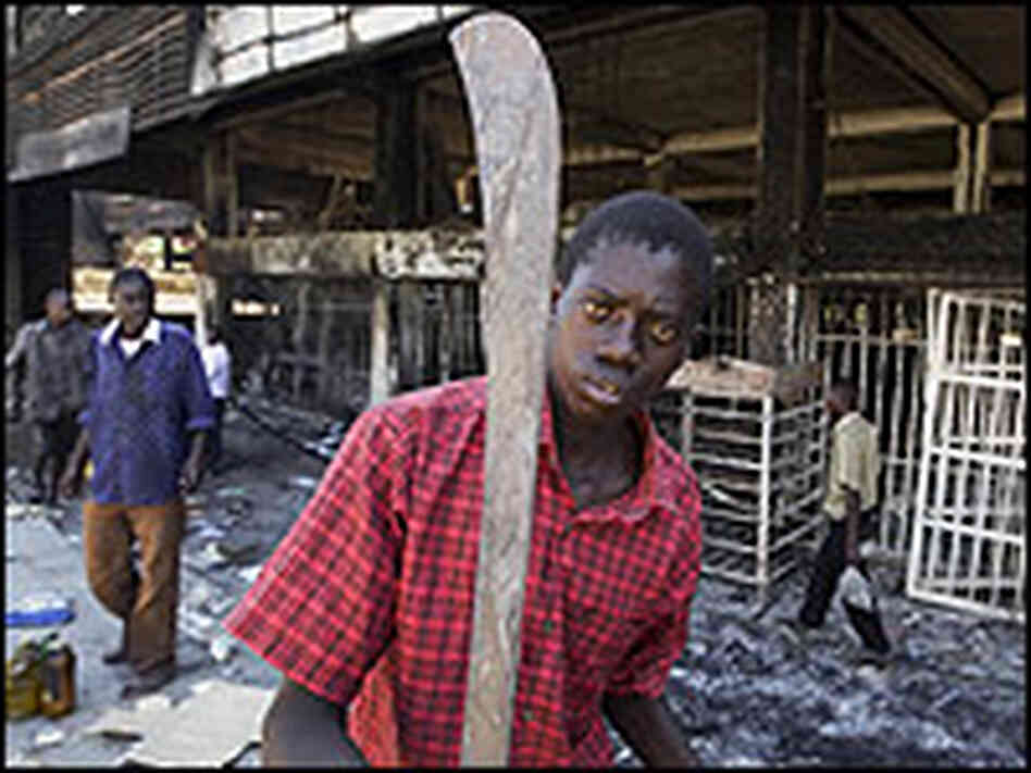 A Kenyan boy holds a machete. A Kenyan boy holds a machete.