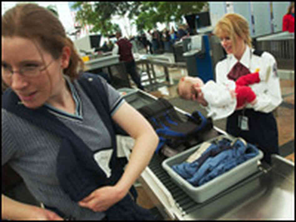 A security screener holds a 6-month-old girl at Denver International Airport. A security screener holds a 6-month-old girl at Denver International Airport.