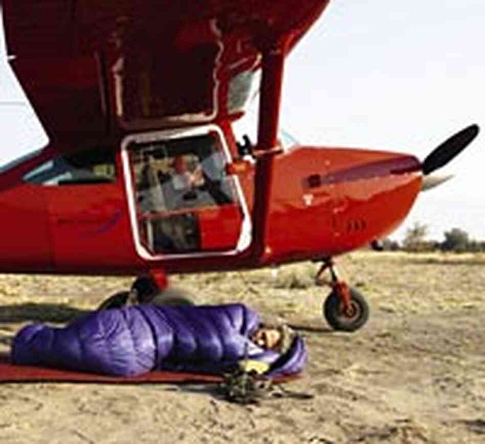 Michael Fay sleeps under the shelter of his plane.