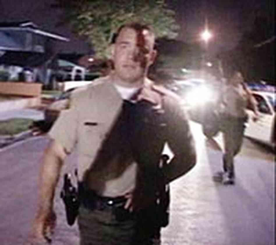 An officer escorts an On Scene Video stringer away from the scene of the May 9, 2005, shooting. An officer escorts an On Scene Video stringer away from the scene of the May 9, 2005, shooting.