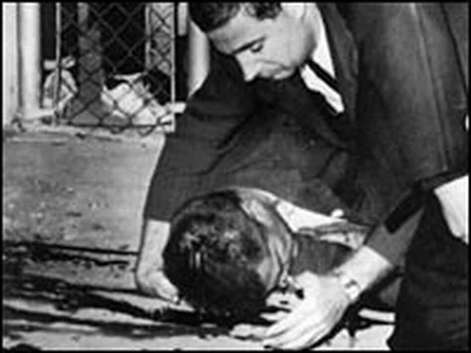 Police officers come to the aid of a bleeding Karl Fleming