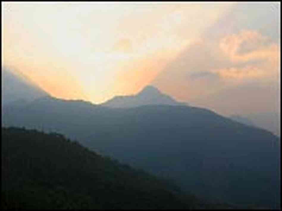 The sun sets over the snow-capped peaks of the Himalayas above the village of Satobri.