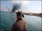 A tractor driver braves oil slicks to fish off a pier in Sidon, Lebanon A tractor driver braves oil slicks to fish off a pier in Sidon, Lebanon
