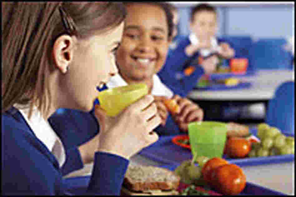 Chidren eat lunch in a cafeteria.. Chidren eat lunch in a cafeteria..