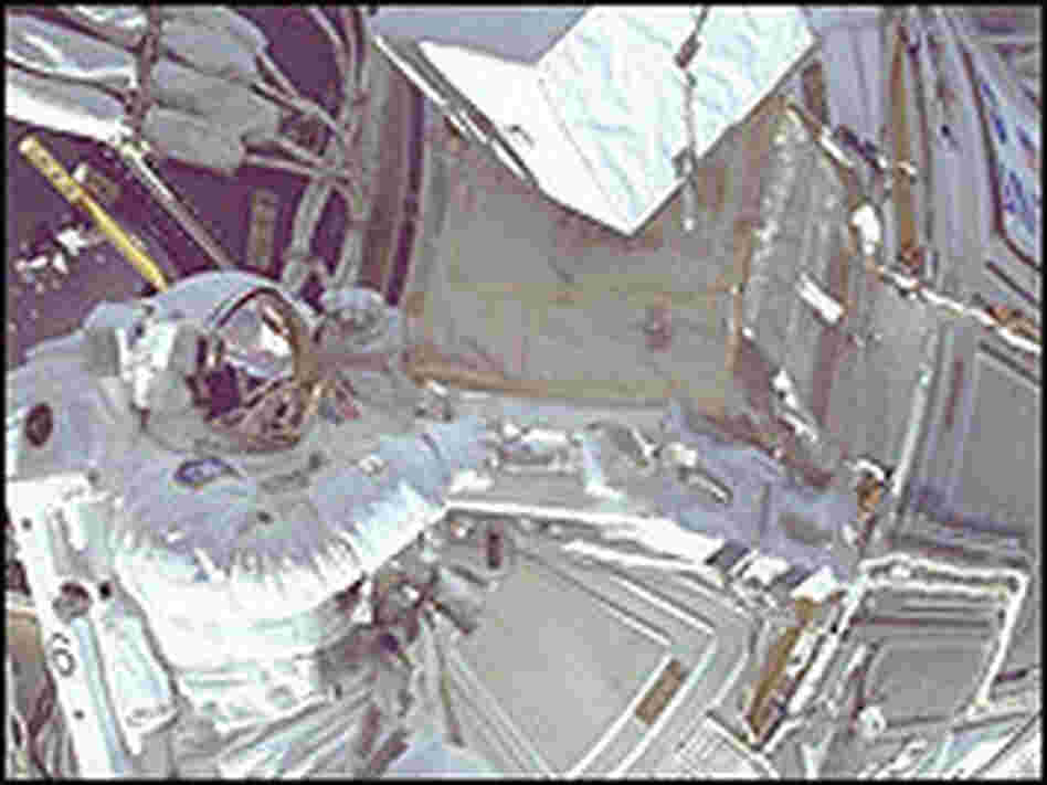 Astronaut Daniel Barry works on the International Space Station during a space walk in 1999.