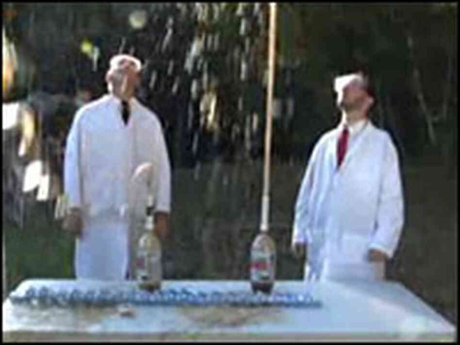 Men stand before erupting bottles of Diet Coke Men stand before erupting bottles of Diet Coke