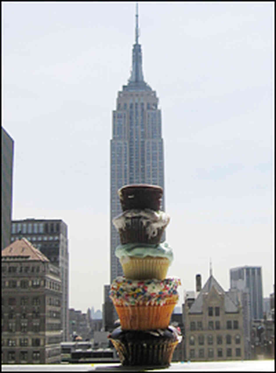 Empire State Building behind stack of cupcakes Empire State Building behind stack of cupcakes