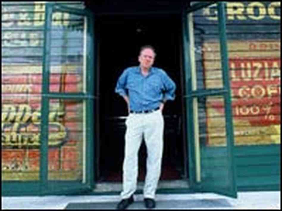 Nick Spitzer stands in front of a colorful storefront in New Orleans.