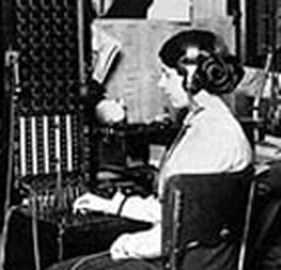 An old-fashioned switchboard operator with headphones and a series of plugs to connect calls. An old-fashioned switchboard operator with headphones and a series of plugs to connect calls.