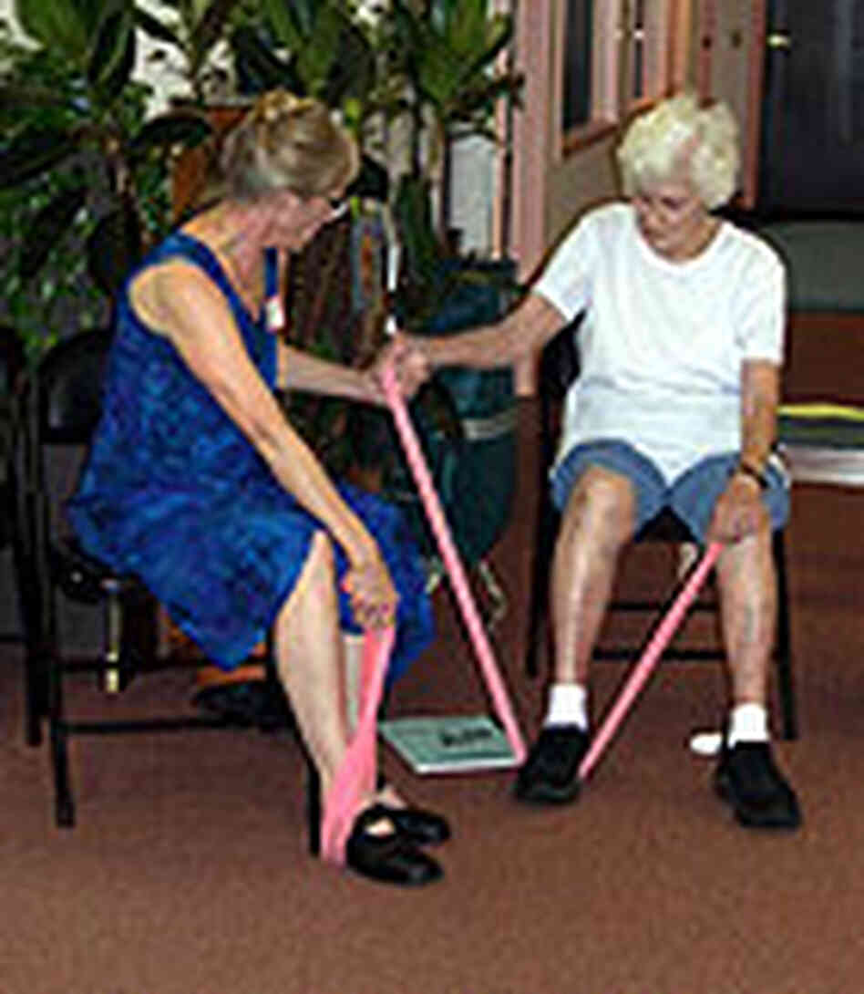 A participant gets some assistance in a class that helps improve seniors' balance, flexibility and A participant gets some assistance in a class that helps improve seniors' balance, flexibility and