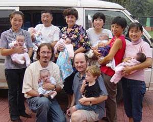 Tim Baker, lower left, John Bentley, lower right, and some other members of the Langfang children's village team, with newly arrived orphans; Photo: Nancy Fraser
