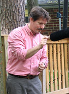 Smithsonian entomologist Nathan Erwin holds a cicada up to the microphone.