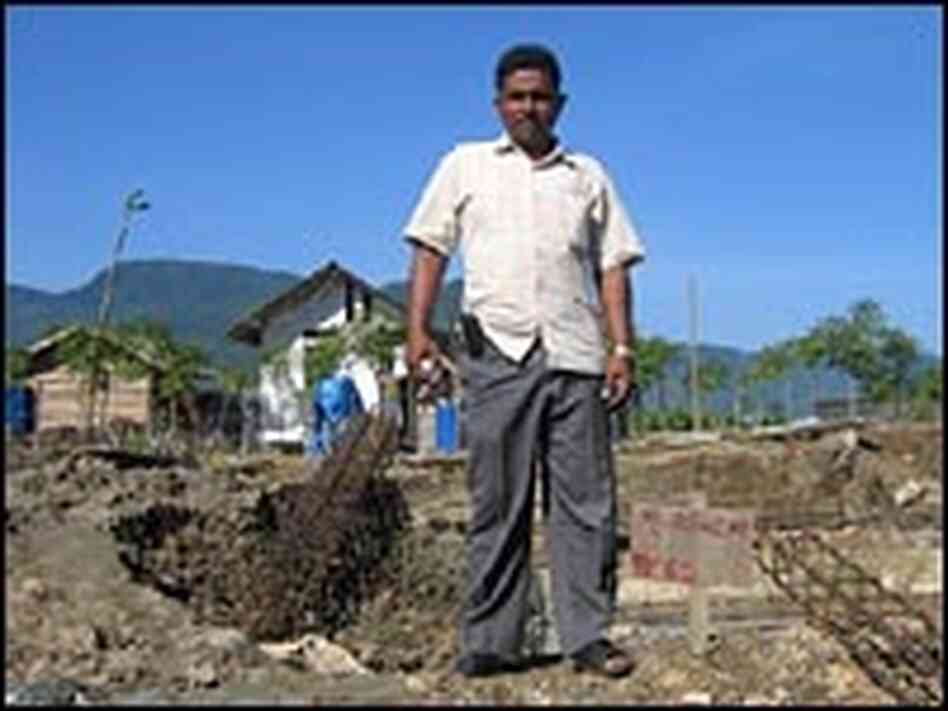 Peuken Bada resident Mursalin stands on the foundation of his new permanent home.