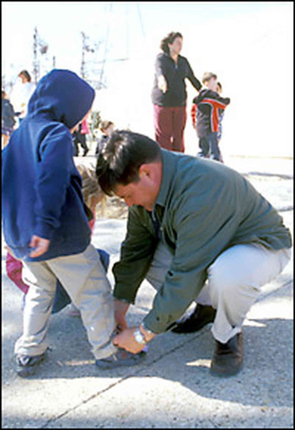 Principal Mark Cumella ties a child's shoe. Credit: Steve Drummond, NPR. Principal Mark Cumella ties a child's shoe. Credit: Steve Drummond, NPR.